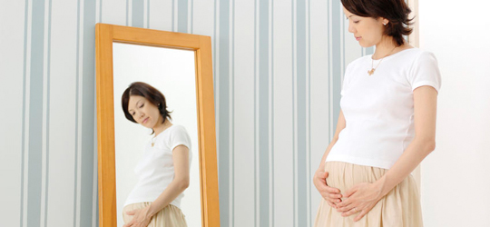 鏡を見る妊婦